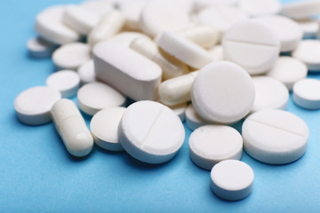 Obraz na płótnie Canvas Pile of pills on color table, closeup