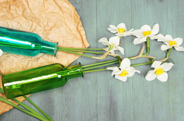 Beautiful daffodils in vases on wooden background