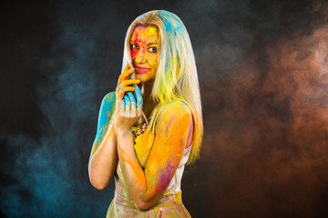 Beautiful young woman covered with colored powder