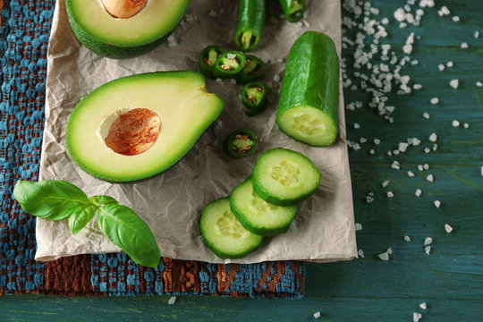 Sliced avocado, cucumber, pepper and lemon lime on wooden background