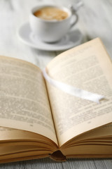 Fototapeta premium Still life with cup of coffee and book, close up