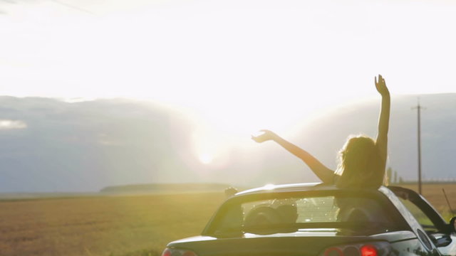 Happy Couple driving convertible car cabriolet on a background
