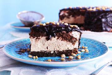 Delicious chocolate cake with icing in plate on table, closeup