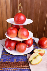 Tasty ripe apples on serving tray on wooden background