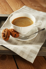 Cup of coffee with cookie on table, closeup
