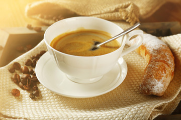 Cup of coffee with cookie on table, closeup