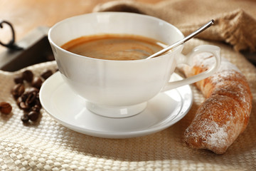 Cup of coffee with cookie on table, closeup