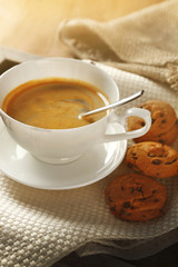 Cup of coffee with cookie on table, closeup