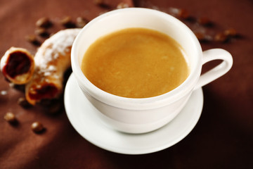 Cup of coffee with cookie on table, closeup
