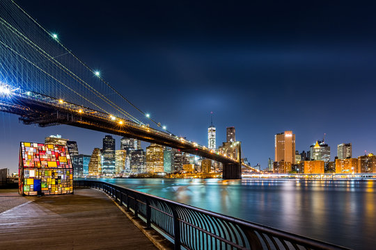 Fototapeta Brooklyn Bridge and the Lower Manhattan skyline by night as viewed from  Brooklyn Bridge Park in New York City