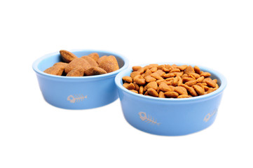 Blue ceramic dogs bowl. Dry dog food in bowl isolated on white background.
