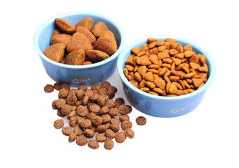 Blue ceramic dogs bowl. Dry dog food in bowl isolated on white background.