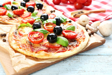 Tasty pizza with vegetables and basil on table close up
