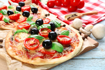 Tasty pizza with vegetables and basil on table close up