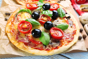 Tasty pizza with vegetables and basil on table close up