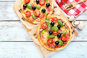 Tasty pizza with vegetables and basil on table close up