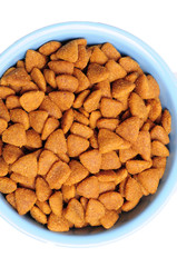 Blue ceramic dogs bowl. Dry dog food in bowl isolated on white background. Dry dog food isolated on white background
