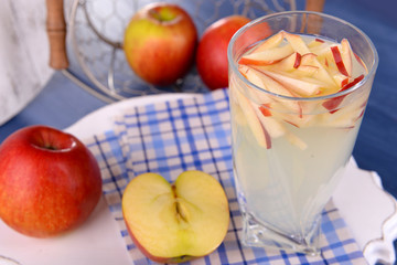 Glass of apple cider with fruits on table close up