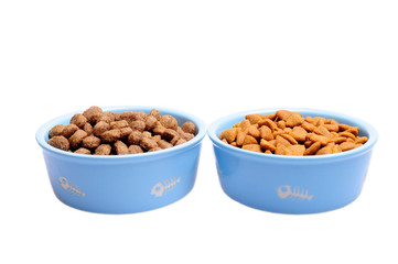 Blue ceramic dogs bowl. Dry dog food in bowl isolated on white background.