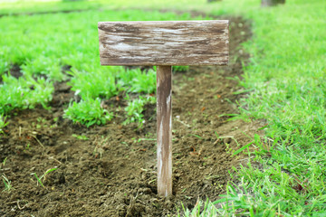 Wooden signboard over grass, outdoors