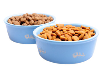Blue ceramic dogs bowl. Dry dog food in bowl isolated on white background.
