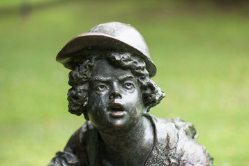 Boy wearing a cap is paying attention to something, and expressing wonder.