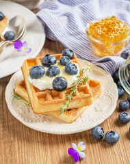 Homemade fresh crispy waffles for breakfast with blueberries and honey