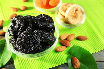 Dried fruits and almonds with leaves on green napkin, closeup