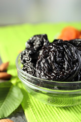 Dried fruits and almonds with leaves on green napkin, closeup