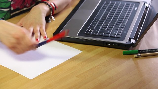 Girl stops to type and writes on a white sheet