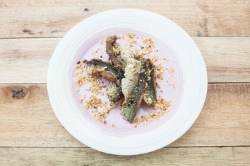 Fried Dried Fish isolated on wood.