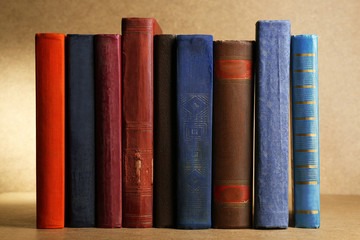 Old books on shelf, close-up, on wooden background