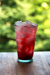 Full glass of water and juice with ice on the wooden kitchen cou