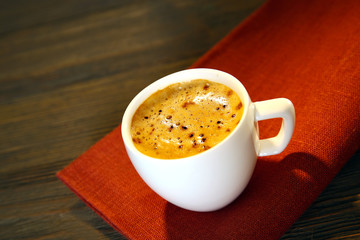 Cup of coffee on napkin on table close up