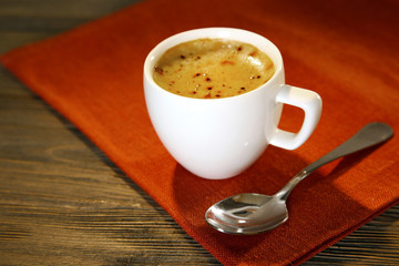 Cup of coffee on napkin on table close up