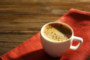 Cup of coffee on napkin on table close up