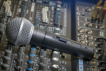 A microphone placed on mixer, stage, music, sound, mixer, audio mixer, and microphone system, Is a...