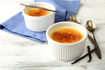 Creme brulee dessert  on napkin, on color wooden background