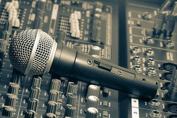 A microphone placed on mixer, stage, music, sound, mixer, audio mixer, and microphone system, Is a...