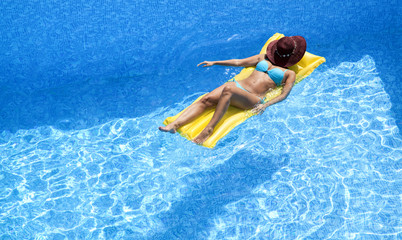 Frau auf Luftmatratze im Pool