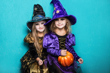 Girls in a suit of a witch. Halloween. Fairy. Tale. Studio portrait on blue background