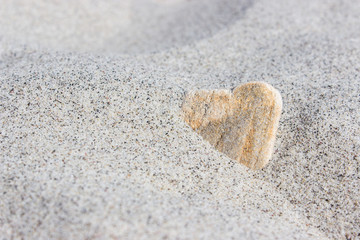 Fototapeta na wymiar Heart / Stone in heart shape in the sand beach