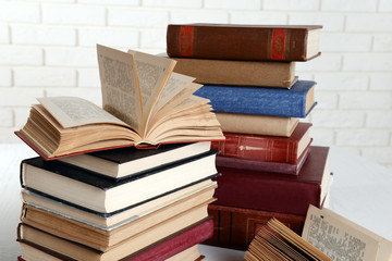 Heap of old books on brick wall background