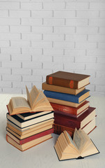 Heap of old books on brick wall background