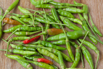 Green and red chili peppers on wooden backgrounds