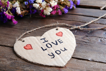 Written message with dry flowers on wooden table close up