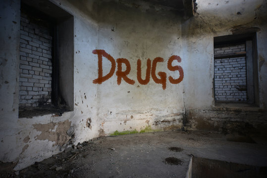 text drugs on the dirty old wall in an abandoned ruined house