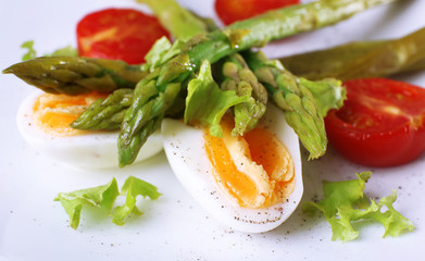 Plate of dietary salad with boiled asparagus and egg, closeup