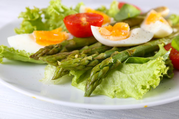 Plate of dietary salad with boiled asparagus and egg, closeup