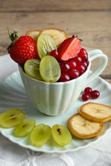 Cup of dessert with fresh fruits on wooden table, closeup